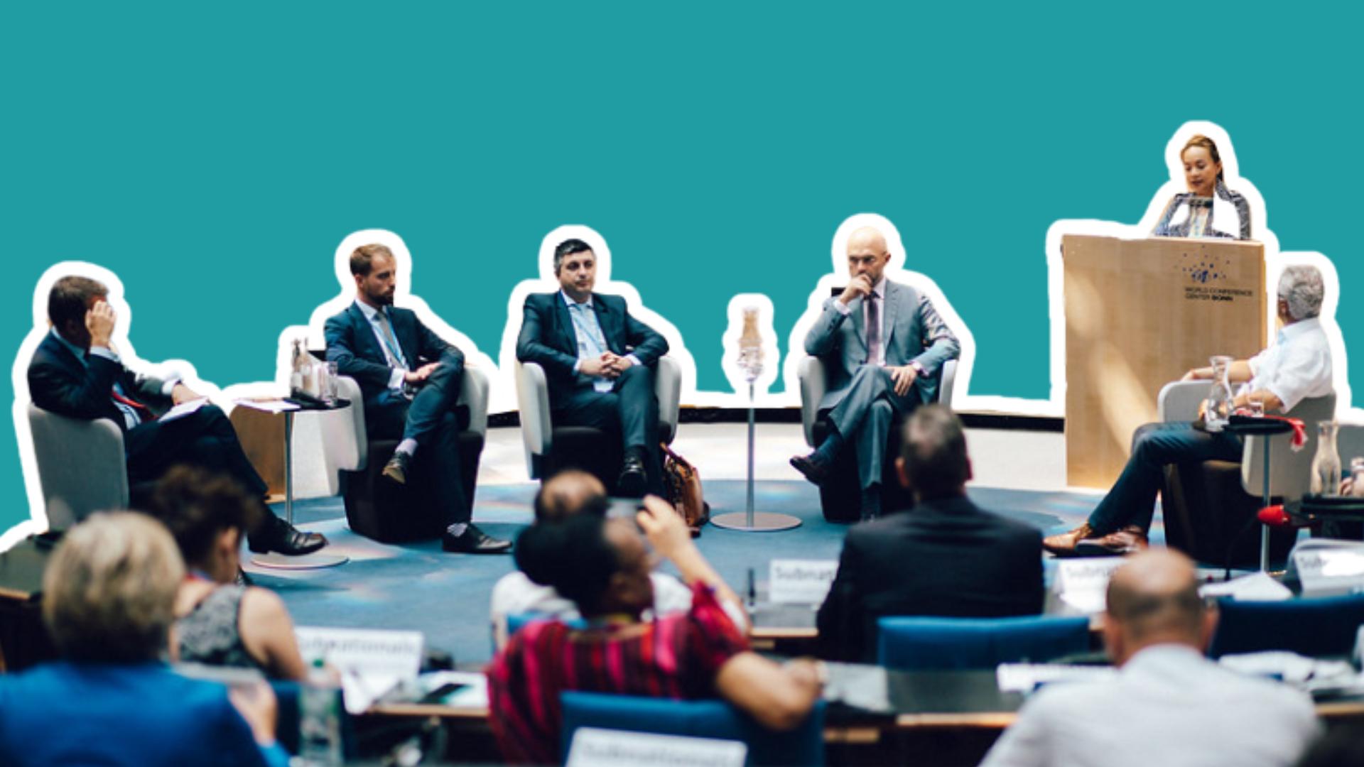 An image from the Bonn Climate Conference featuring delegates in discussion